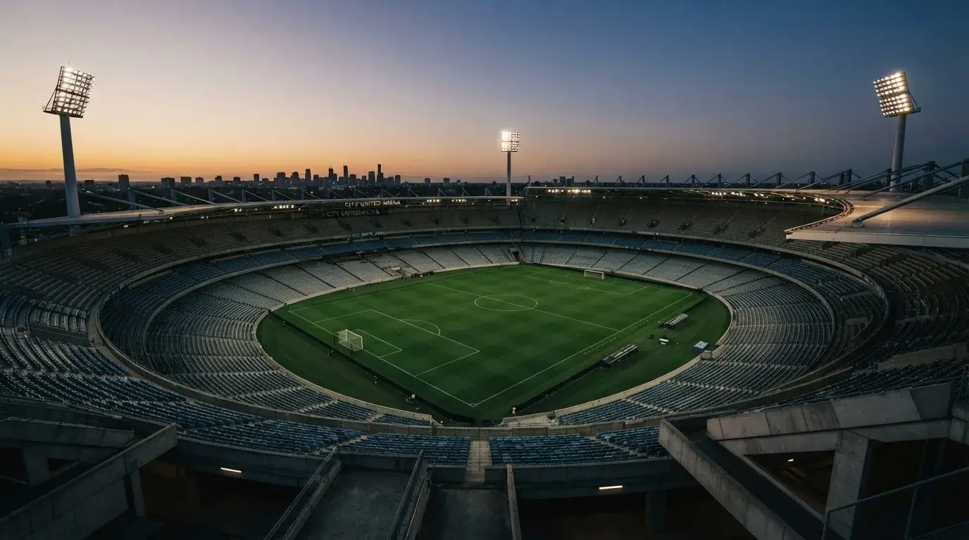 Een leeg voetbalstadion met lichtmasten bij schemering